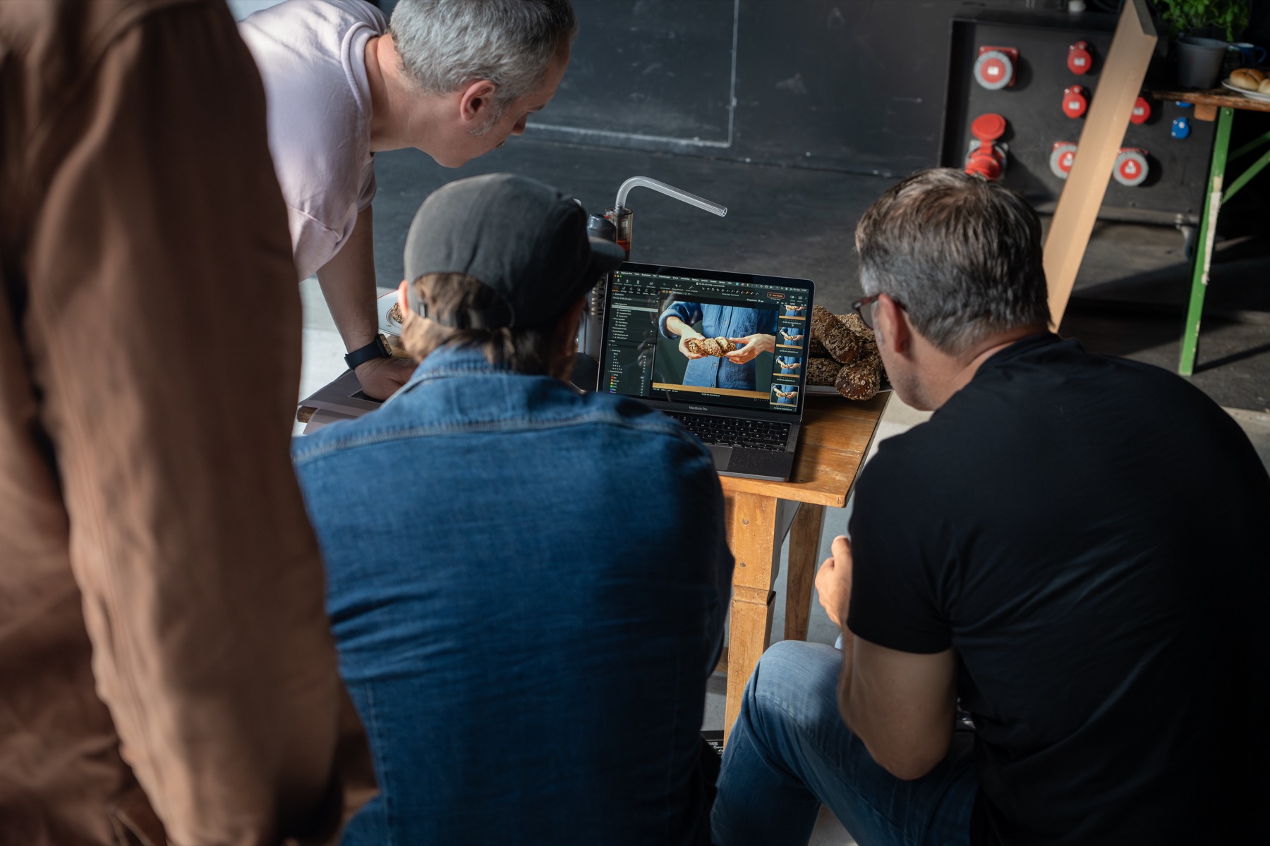 Produktionsteam begutachtet Aufnahmen am Laptop bei einem Werbedreh